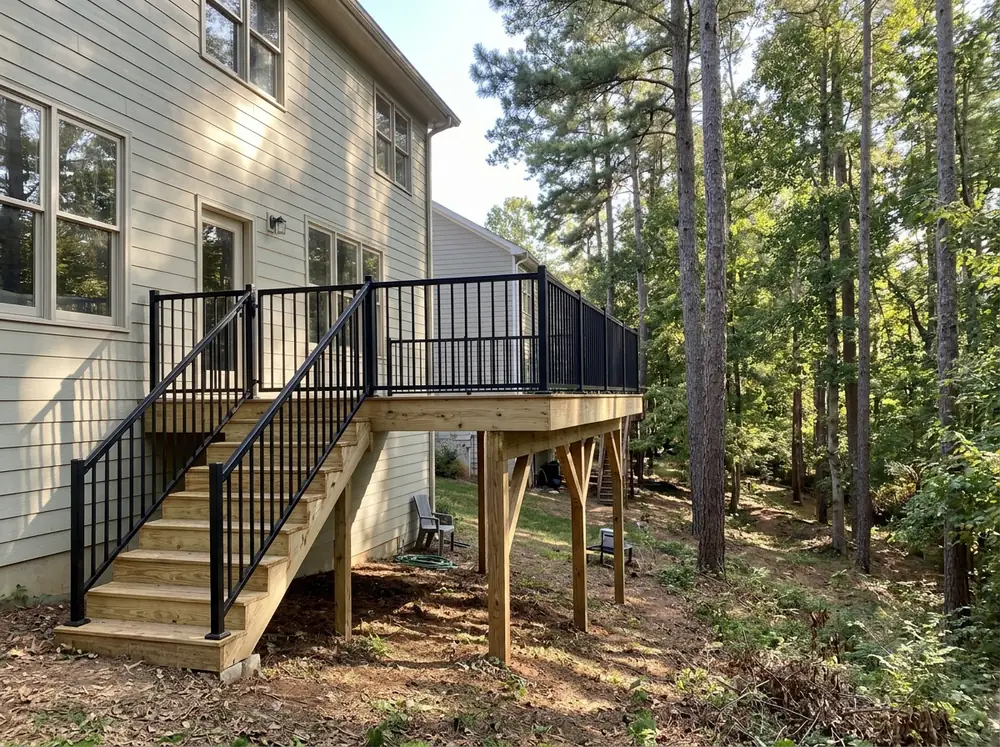 Black aluminum deck railing with slim pickets around a raised deck