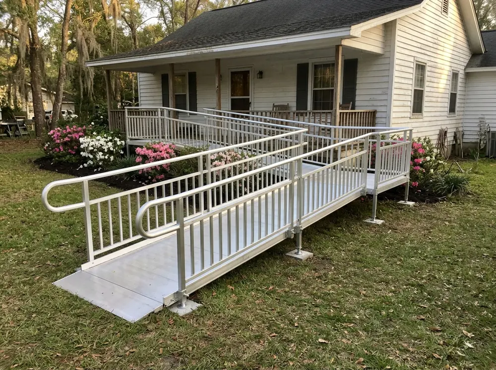 Modular aluminum ramp with handrails on both sides leading to a front porch