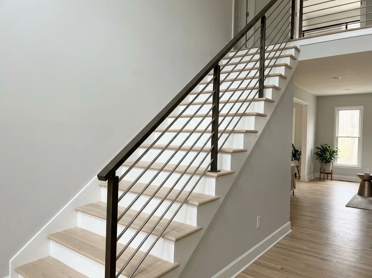 Open-stringer staircase with thin horizontal stainless rods running between dark metal posts